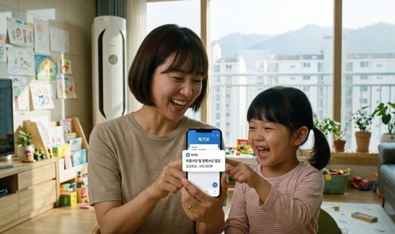 아이와 엄마가 행복하게 웃으며 스마트폰으로 아동 양육 지원금을 확인하는 모습